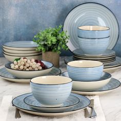 a table topped with plates and bowls next to a bowl filled with vegetables on top of it