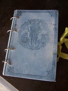 an open book with a yellow ribbon around it on a table next to a pair of scissors