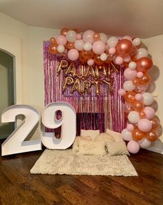 a room decorated with balloons, streamers and the number twenty nine in front of it