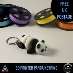 a panda keychain sitting on top of a table next to spools of thread