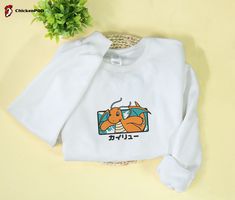 Dragonite Embroidered Sweatshirt: Perfect Holiday Gift for Christmas and Birthdays White T-shirt With Embroidered Text For Winter, White Sweatshirt For Winter Gift, White Winter Sweatshirt For Gift, White Winter Sweatshirt Gift, White Winter Sweatshirt As A Gift, White Embroidered Sweatshirt As Winter Gift, White T-shirt With Embroidered Graphics For Winter, White Embroidered Graphic T-shirt For Winter, White Long Sleeve Sweatshirt With Letter Embroidery