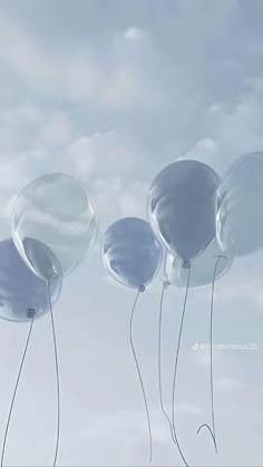 three balloons floating in the air on a cloudy day