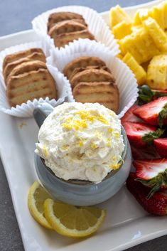 a plate with strawberries, lemons and cookies on it