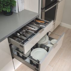 an open drawer in the middle of a kitchen