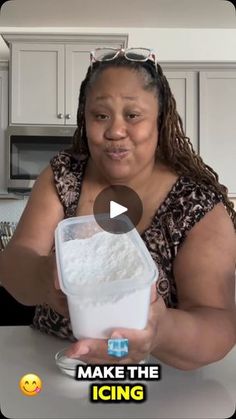 a woman is holding a container of ice cream