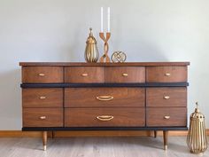 a wooden dresser sitting on top of a hard wood floor next to a white wall