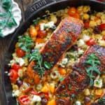 a pan filled with meat and vegetables on top of a wooden table