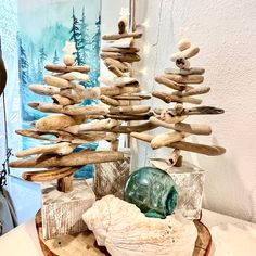 Driftwood trees just in time for the holiday season.   These trees come in a variety of sizes and choice of unfinished natural cedar base or a distressed white base for the coastal farmhouse vibe.  Top of trees have a wood bead and a natural capiz shell star.  There is one large tree 16-17" tall that has a natural driftwood top.  Sizes range from  Small 12-13" tall  Med/large15-16" tall  Large 16-17" tall  The medium to large sizes have a 4" base The small trees have a 2.5" base See listing photo options for more details. Diy Driftwood Christmas Tree, Hanging Driftwood Christmas Tree, Drift Wood Tree Topper, Driftwood Christmas Tree Wall Hanging, Driftwood Seaglass Ornament, Driftwood Christmas Tree, Capiz Shell, Small Trees, Christmas Table Decorations