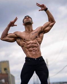 a man standing on top of a field with his hands in the air and arms out