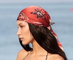 a woman wearing a bandana on the beach