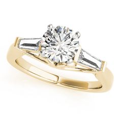 a yellow gold engagement ring with two baguets