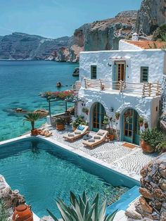 an outdoor swimming pool with chaise lounges next to the water and mountains in the background