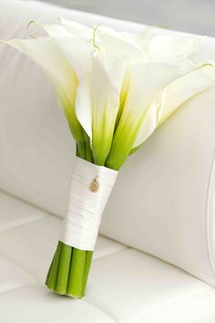 a bouquet of white flowers sitting on top of a couch