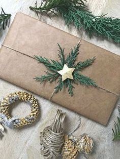 some christmas decorations are laying out on the floor next to a wrapped present box and twine