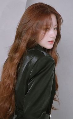 a woman with long red hair wearing a black leather jacket