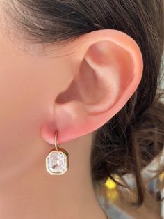 Classic setting, with a modern yet vintage vibe. Each bezel set stone, surrounded by milgrain detail, is attached to fixed wire that hangs from the earlobes beautifully. (Stone shape may vary slightly based on availability.). Offered in Colorless & Pink. 14kt Gold Each earring has a 2.5ct Premium Grade Zircon Exquisitely Handcrafted in Los Angeles Vintage Vibe, Rose Gold Earrings, White Rose Gold, 14kt Gold, Vintage Vibes, Bezel Setting, Emerald Cut, White Roses, Stone Color