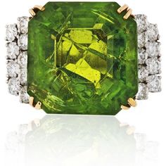 Indulge in the captivating allure of the Platinum & 18K Yellow Gold 45 Carat Large Peridot Diamond Ring. This exquisite piece is a celebration of strength, symbolized by the August birthstone, peridot. Legend has it that the green peridot crystals, found in the ashes of volcanic eruptions, were once believed to be the tears of the volcano goddess, Pele. Adorned with a vibrant emerald-cut peridot gemstone, this ring emanates a brilliant green hue that enchants the eye.Crafted with meticulous atte Formal Peridot Diamond Ring With Center Stone, Green Multi-stone Diamond Ring For Formal Occasions, Formal Green Multi-stone Diamond Ring, Luxury Green Diamond Ring Hallmarked, Formal Peridot Diamond Ring With Prong Setting, Luxury Hallmarked Green Diamond Ring, Luxury Green Hallmarked Diamond Ring, Green Peridot Rings With Brilliant Cut, Exquisite Green Multi-stone Diamond Ring