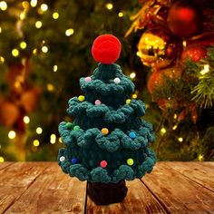 a crocheted christmas tree sitting on top of a wooden table