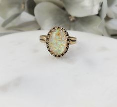 "This popular mosaic shell ring is made with an oval 10x14mm mosaic shell resin cabochon (in your choice of light cabochon or dark cabochon_, which we set in a lovely antiqued bronze crown ring bezel. This adjustable ring will fit just about any finger and makes a great beachcomber jewelry gift for her. Thank you for looking. NOTE: The 6th photo is a picture of the back of a similar ring, just so you can see how this ring can easily be sized to fit just about any ladies ring size. - Shop Gemsicl Gold Oval Opal Ring For Jewelry Making, Antique Oval Opal Ring As Gift, Handmade Oval Opal Ring For Wedding, Handmade Oval Opal Wedding Ring, Vintage Oval Cabochon Opal Ring Gift, Handmade Gold Opal Oval Ring, Beach Bridesmaids Gifts, Mosaic Ring, Seashell Ring