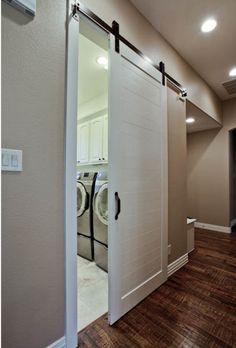 an open door leading to a washer and dryer in a room with hard wood floors