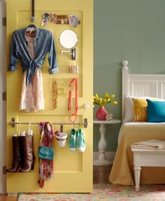 there is a yellow door with shoes hanging on it and a white bed in the background