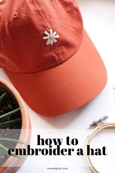 an orange hat sitting on top of a white table next to a potted plant