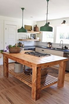 a wooden table sitting in the middle of a kitchen next to a stove top oven