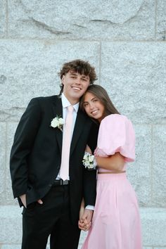 a young man and woman in formal wear standing next to each other