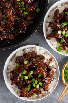 three bowls filled with beef and rice next to chopsticks on a table top