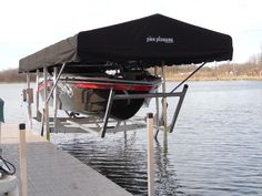 a boat tied to a dock with a cover over it