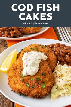 two fried fish cakes on a plate with coleslaw and beans