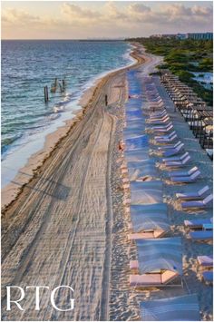 the beach is lined with umbrellas and chairs