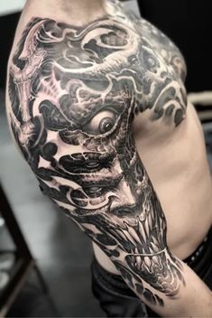 a man with a dragon tattoo on his arm is shown in black and grey ink