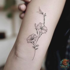 a small flower tattoo on the arm