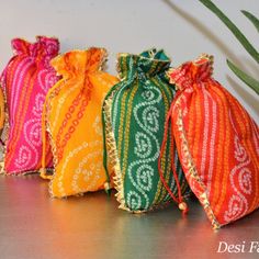 Bandhini is a beautiful fabric that requires hand-crafted skills. About a thousand years old, bandhini cloth involves a long process that can only be done by skilled artisans at by hand, producing beautiful dotted patterns. These bandhini potlis by Desi Favors will win your heart and turn heads at any and every occasion. * Set of 4 colorful potlis that are perfect for return gifts during festivals or weddings * Each potli bag is 9x7 inches in size * Comes in four vibrant colors of pink, green, r Festive Potli Bag With Pallu As Gift, Festive Gift Potli Bag With Pallu, Festival Zari Work Potli Bag For Gift, Festival Gift Potli Bag With Zari Work, Diwali Gift Pouch With Zari Work, Red Potli Bag For Festivals And Gifts, Diwali Gift Potli Bag, Festive Handmade Multicolor Pouch, Multicolor Zari Work Potli Bag For Diwali