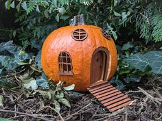 an orange pumpkin shaped like a house in the woods