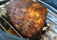 a piece of meat sitting on top of a metal rack in a blue container with foil