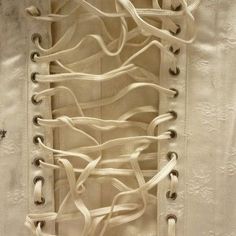 the inside of a white dress with laces on it