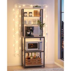 a microwave oven sitting on top of a wooden shelf next to a window with christmas lights