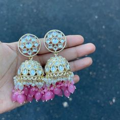 Our Pink Navi Jhumka Earrings are the perfect Jhumkas. These beauties are handcrafted to perfection with a high quality Kundan with hydro beads, and pearls on Gold Plating. Specifications Materials used: Kundan, Pearls, hydro beads, Gold Plating Weight: 35 g Height: 3 inches At Romikas, we pride ourselves on the craftsmanship and high quality of our jewelry, designed to enhance your natural beauty. Please contact us with any questions. Cheap Festive Jhumkas With Latkans, Cheap Jhumkas For Navratri, Chandbali Beaded Danglers For Festivals, Temple Jewelry Chandbali Beaded Earrings, Beaded Chandbali Danglers For Festivals, Festive Bollywood Style Earrings With Round Beads, Bollywood Style Round Bead Earrings For Festive Occasions, Kundan Beaded Earrings For Temple Jewelry, Beaded Chandbali Danglers For Celebration