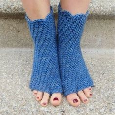 a woman's feet with blue knitted socks and toenails on the steps