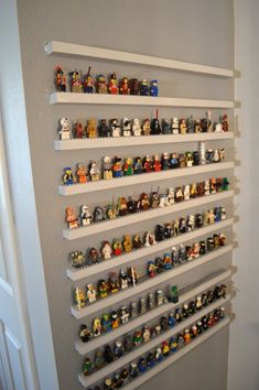 a wall shelf filled with legos on top of white shelves