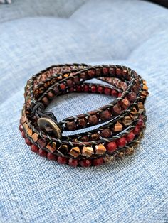 Handcrafted quadruple leather wrap bracelet, made with czech glass and semiprecious stone beads. Approximate wrist width of 6.5"; see photos for sizing. Multi-strand Faceted Beads Wrap Bracelet For Jewelry Making, Unique Adjustable Wrap Bracelet With Round Beads, Red Adjustable Bohemian Wrap Bracelet, Adjustable Multi-strand Bracelets With Faceted Beads, Adjustable Brown Czech Glass Beaded Bracelet, Multi-strand Wrap Bracelet With Faceted Beads, Handmade Adjustable Red Wrap Bracelet, Adjustable Red Handmade Wrap Bracelet, Adjustable Bracelets With Faceted Beads