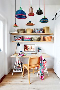 a desk with some baskets and lights hanging from it's ceiling in a room