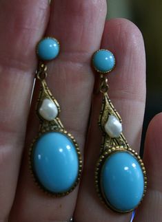 "Very fine pair of Czechoslovakian earrings from the Art Nouveau era, circa 1910. Beautifully shaped pendant earrings in gold tone appointed with French blue opaline type poured glass cabochons and glass button tops. The middle section accented with lovely natural baroque pearls. These pearls are often referred to as \"tooth\" pearls or Mississippi river pearls due to their unusual shape. The pearls are well matched and have beautiful lustrous nacre... amazing for  earrings over a hundred years Victorian Cabochon Drop Earrings, Blue Art Deco Drop Earrings, Vintage Cabochon Dangle Earrings, Vintage Blue Drop Earrings Jewelry, Blue Elegant Earrings, Elegant Blue Cabochon Clip-on Earrings, Antique Blue Earrings, Vintage Blue Drop Earrings, Victorian Blue Earrings For Formal Occasions