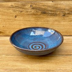 a blue bowl sitting on top of a wooden table