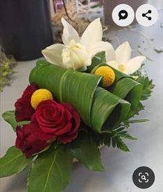 a bouquet of flowers on a table with an odd face drawn in the background,