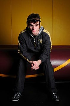 a man sitting on top of a bench in front of a yellow and red wall