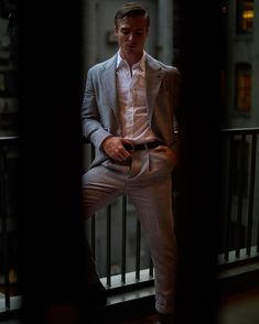 a man in a suit sitting on a balcony