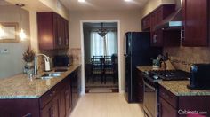 a kitchen with dark wood cabinets and granite counter tops